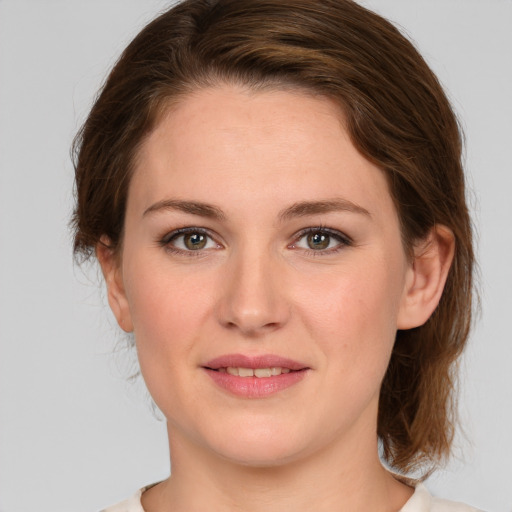 Joyful white young-adult female with medium  brown hair and green eyes