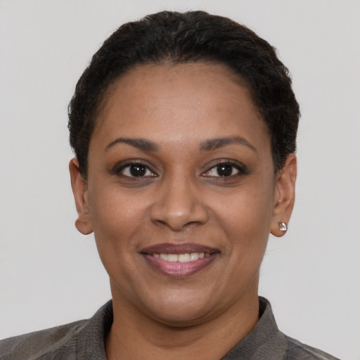 Joyful black young-adult female with short  black hair and brown eyes