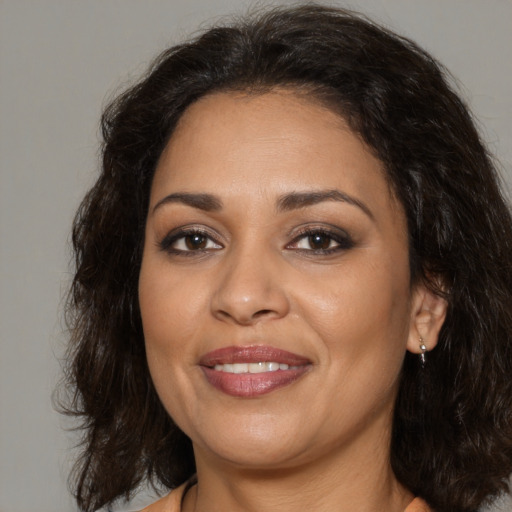 Joyful latino adult female with medium  brown hair and brown eyes