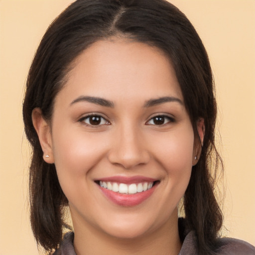 Joyful white young-adult female with long  brown hair and brown eyes