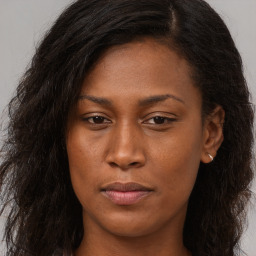 Joyful black young-adult female with long  brown hair and brown eyes