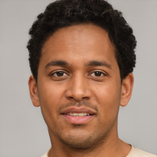 Joyful latino young-adult male with short  brown hair and brown eyes