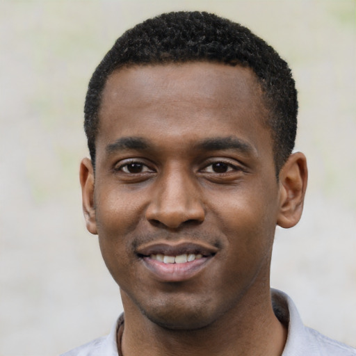 Joyful black young-adult male with short  black hair and brown eyes