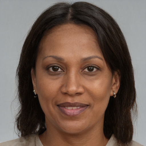 Joyful black adult female with medium  brown hair and brown eyes