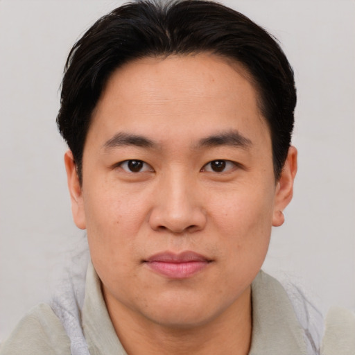 Joyful asian young-adult male with short  brown hair and brown eyes