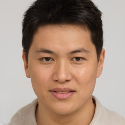 Joyful asian young-adult male with short  brown hair and brown eyes