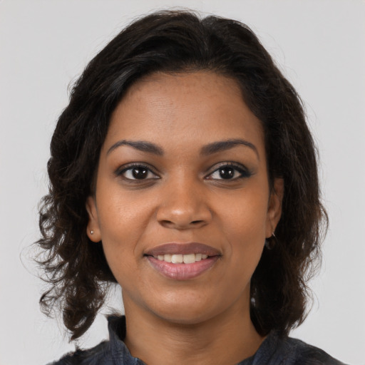 Joyful black young-adult female with long  brown hair and brown eyes