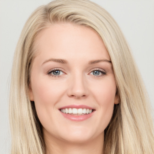 Joyful white young-adult female with long  brown hair and blue eyes