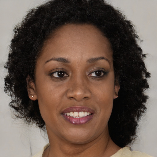 Joyful black young-adult female with short  brown hair and brown eyes