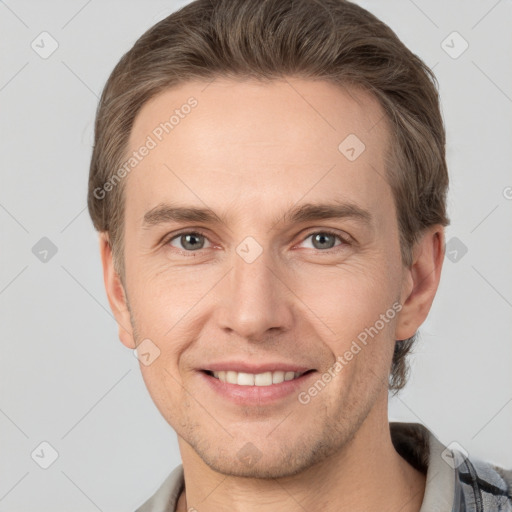 Joyful white young-adult male with short  brown hair and grey eyes