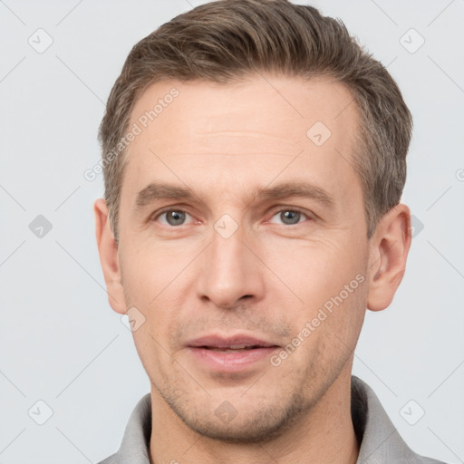 Joyful white adult male with short  brown hair and grey eyes