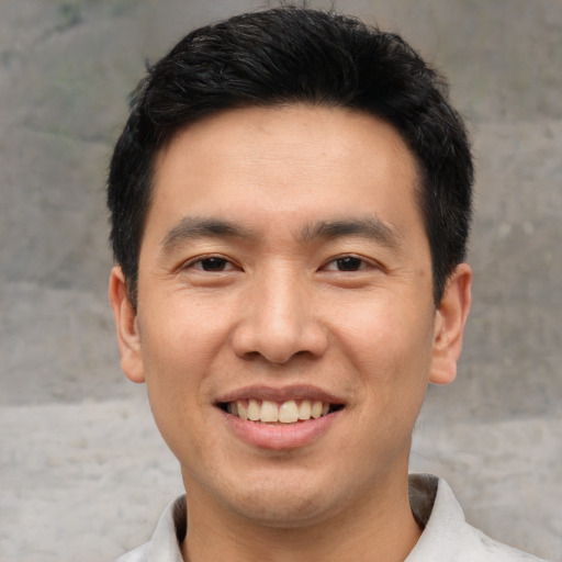 Joyful asian young-adult male with short  black hair and brown eyes