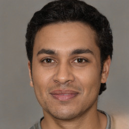 Joyful latino young-adult male with short  brown hair and brown eyes