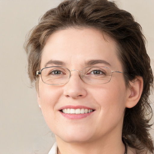 Joyful white adult female with medium  brown hair and blue eyes