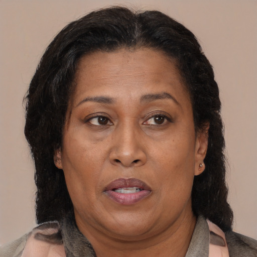 Joyful latino adult female with medium  brown hair and brown eyes
