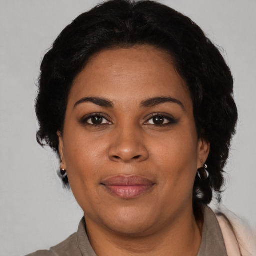 Joyful black young-adult female with long  brown hair and brown eyes