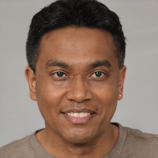 Joyful black young-adult male with short  black hair and brown eyes