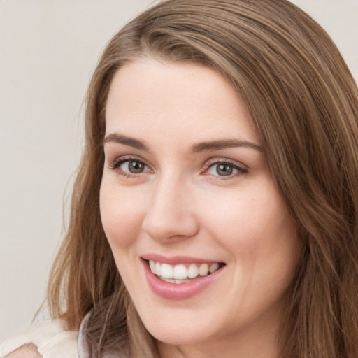 Joyful white young-adult female with long  brown hair and green eyes