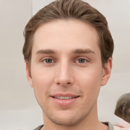 Joyful white young-adult male with short  brown hair and grey eyes