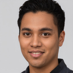 Joyful latino young-adult male with short  brown hair and brown eyes