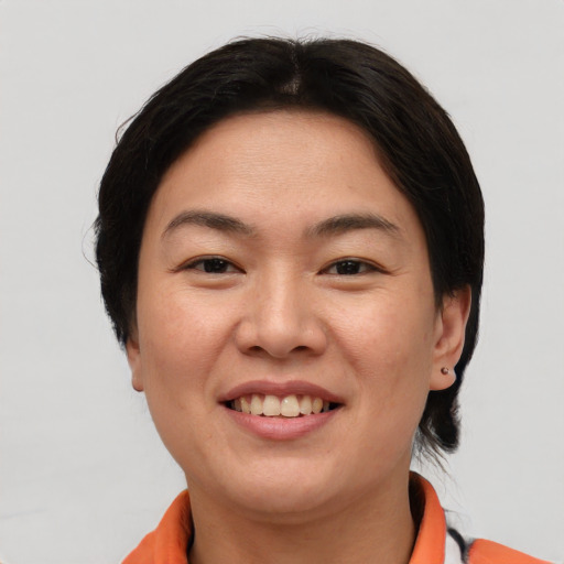 Joyful asian young-adult female with short  brown hair and brown eyes
