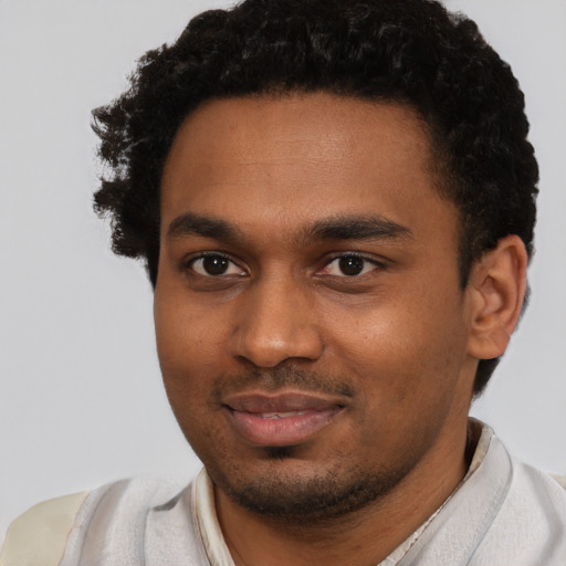 Joyful black young-adult male with short  brown hair and brown eyes
