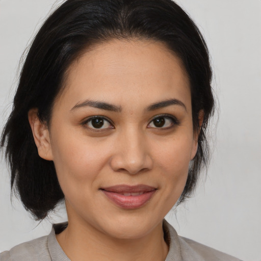 Joyful latino young-adult female with medium  brown hair and brown eyes