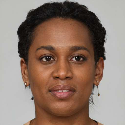 Joyful black young-adult female with short  brown hair and brown eyes