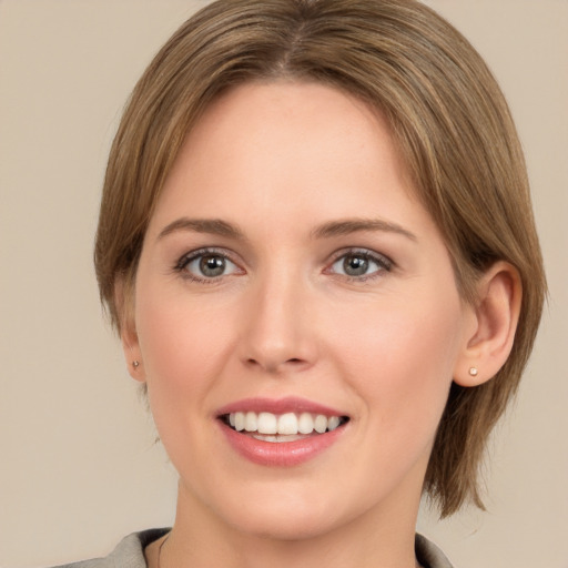 Joyful white young-adult female with medium  brown hair and grey eyes