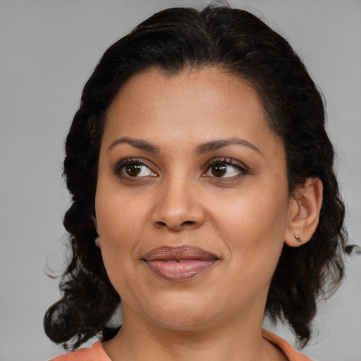 Joyful latino adult female with medium  brown hair and brown eyes