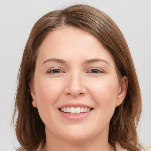 Joyful white young-adult female with medium  brown hair and grey eyes