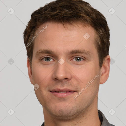 Joyful white young-adult male with short  brown hair and grey eyes