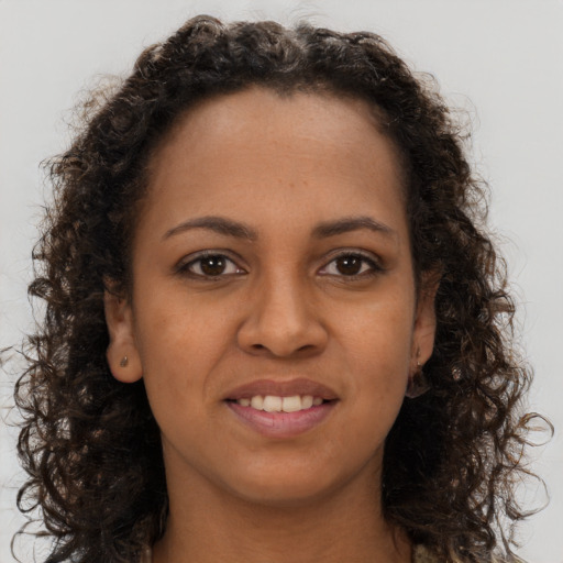 Joyful black young-adult female with long  brown hair and brown eyes