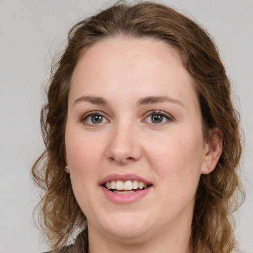 Joyful white young-adult female with medium  brown hair and green eyes