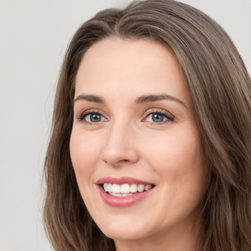 Joyful white young-adult female with long  brown hair and blue eyes