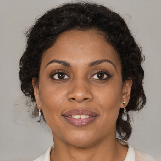Joyful black young-adult female with medium  brown hair and brown eyes
