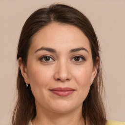 Joyful white young-adult female with long  brown hair and brown eyes