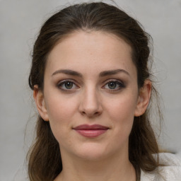 Joyful white young-adult female with medium  brown hair and grey eyes