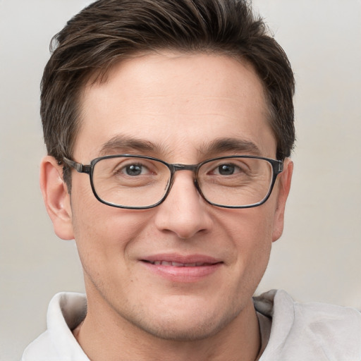 Joyful white young-adult male with short  brown hair and grey eyes