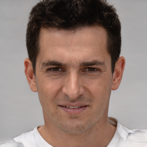 Joyful white adult male with short  brown hair and brown eyes