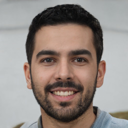 Joyful white young-adult male with short  black hair and brown eyes