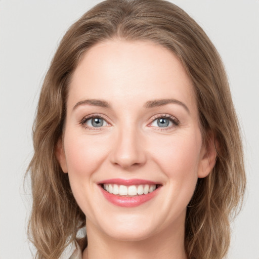 Joyful white young-adult female with long  brown hair and green eyes