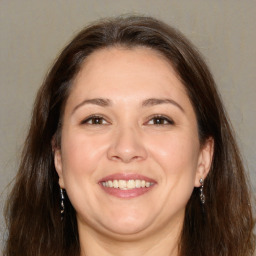 Joyful white adult female with long  brown hair and brown eyes