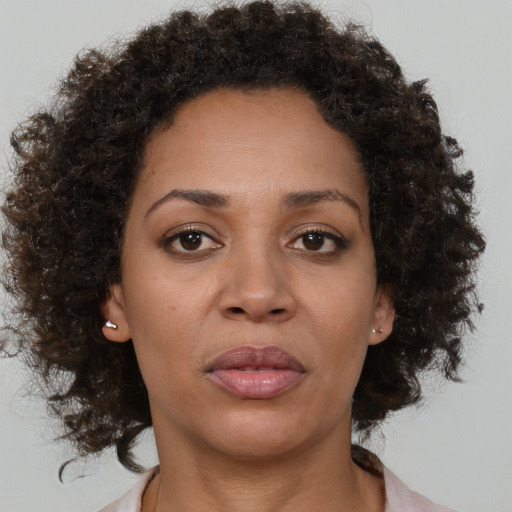 Joyful black young-adult female with medium  brown hair and brown eyes