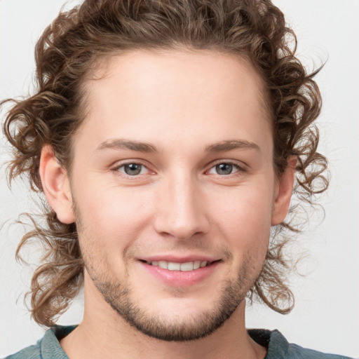 Joyful white young-adult male with medium  brown hair and blue eyes