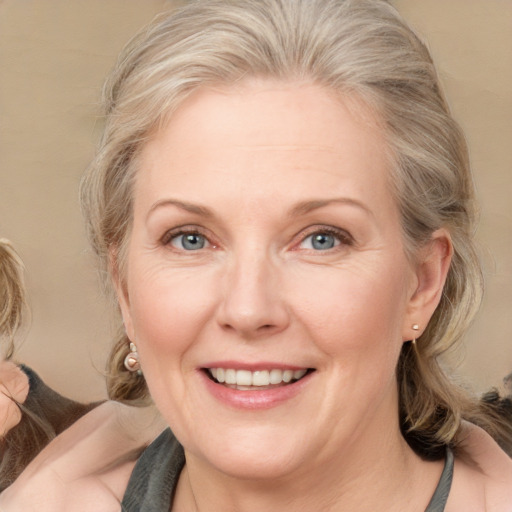 Joyful white adult female with medium  brown hair and blue eyes