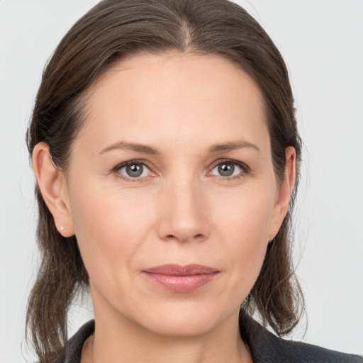 Joyful white young-adult female with medium  brown hair and grey eyes