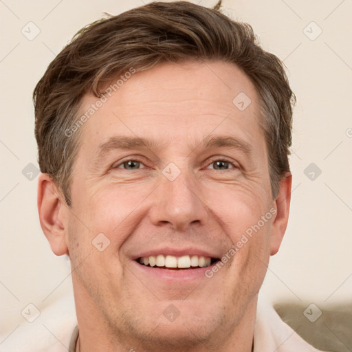 Joyful white adult male with short  brown hair and grey eyes