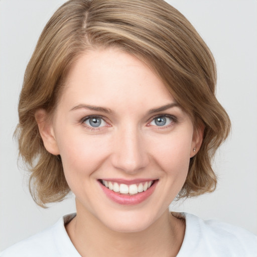 Joyful white young-adult female with medium  brown hair and grey eyes