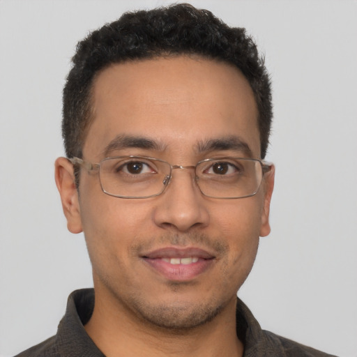 Joyful latino young-adult male with short  brown hair and brown eyes